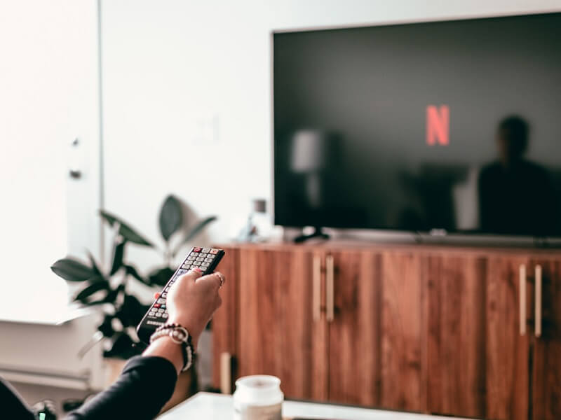 a person turning on Netflix; the concept of sharing a streaming password