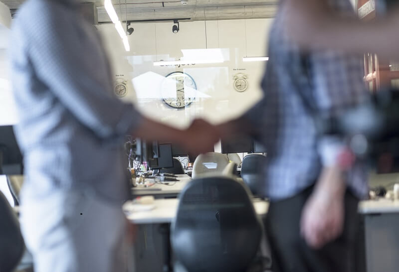 two people shaking hands, the concept of password management for MSP